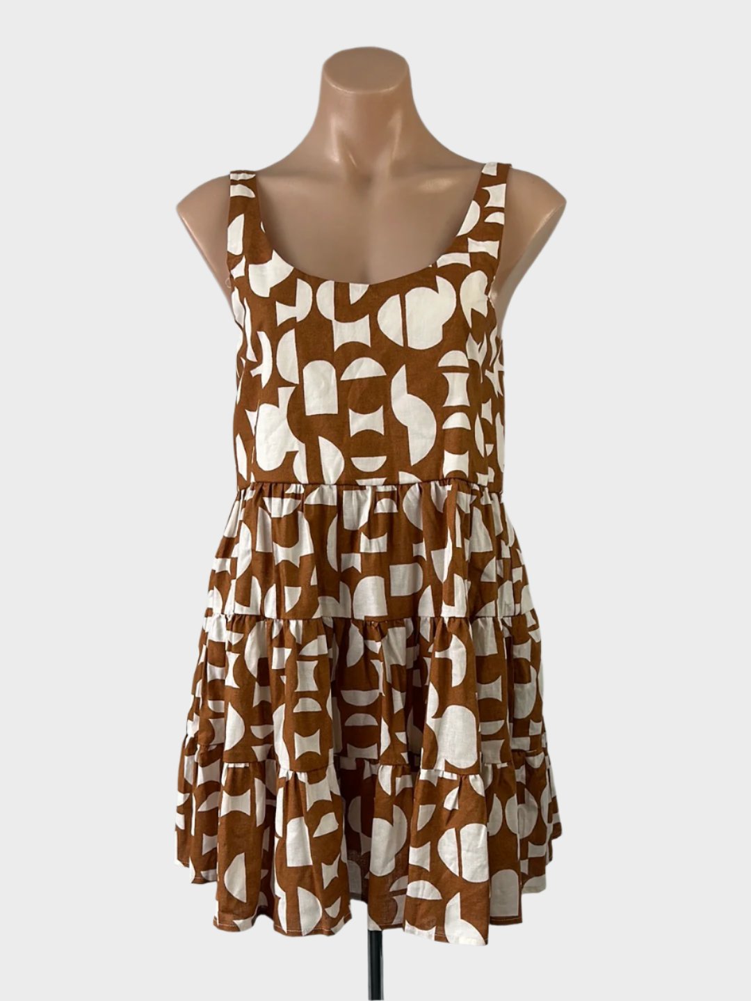 Designer Mister Zimi sleeveless smock dress in brown & white cotton-linen with retro geometric print, u-shaped neck, gathered waist, and tiered skirt for smart casual or resort.