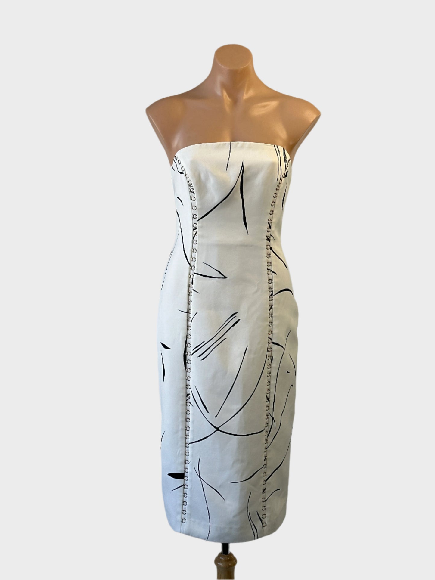 Designer Keepsake white and black line print strapless sheath dress with metal ring seams for special events or evening wear.