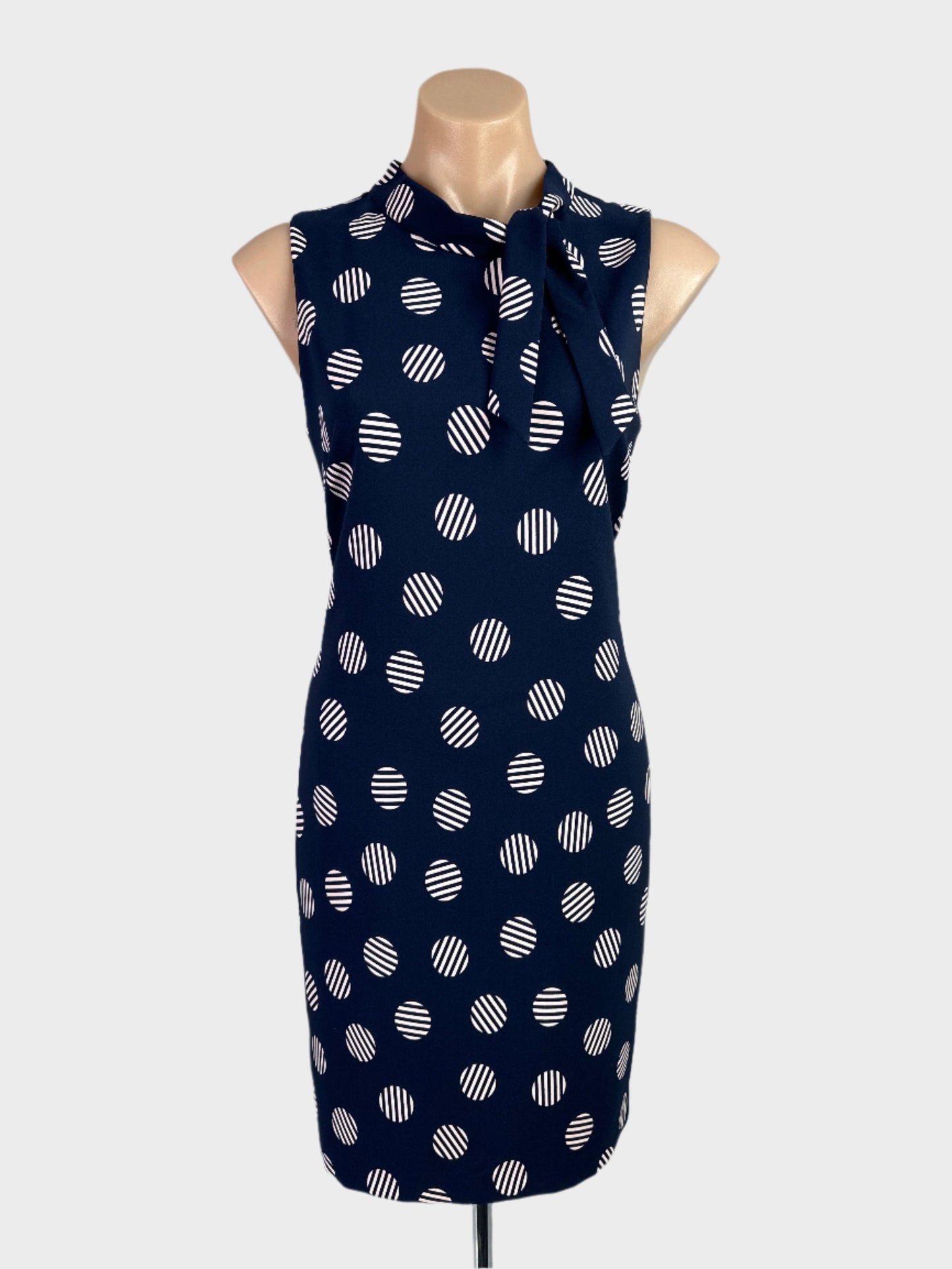 Review blue and pink retro 60's sleeveless shift dress with striped dot print, jabot collar and straight skirt for office or smart casual wear.
