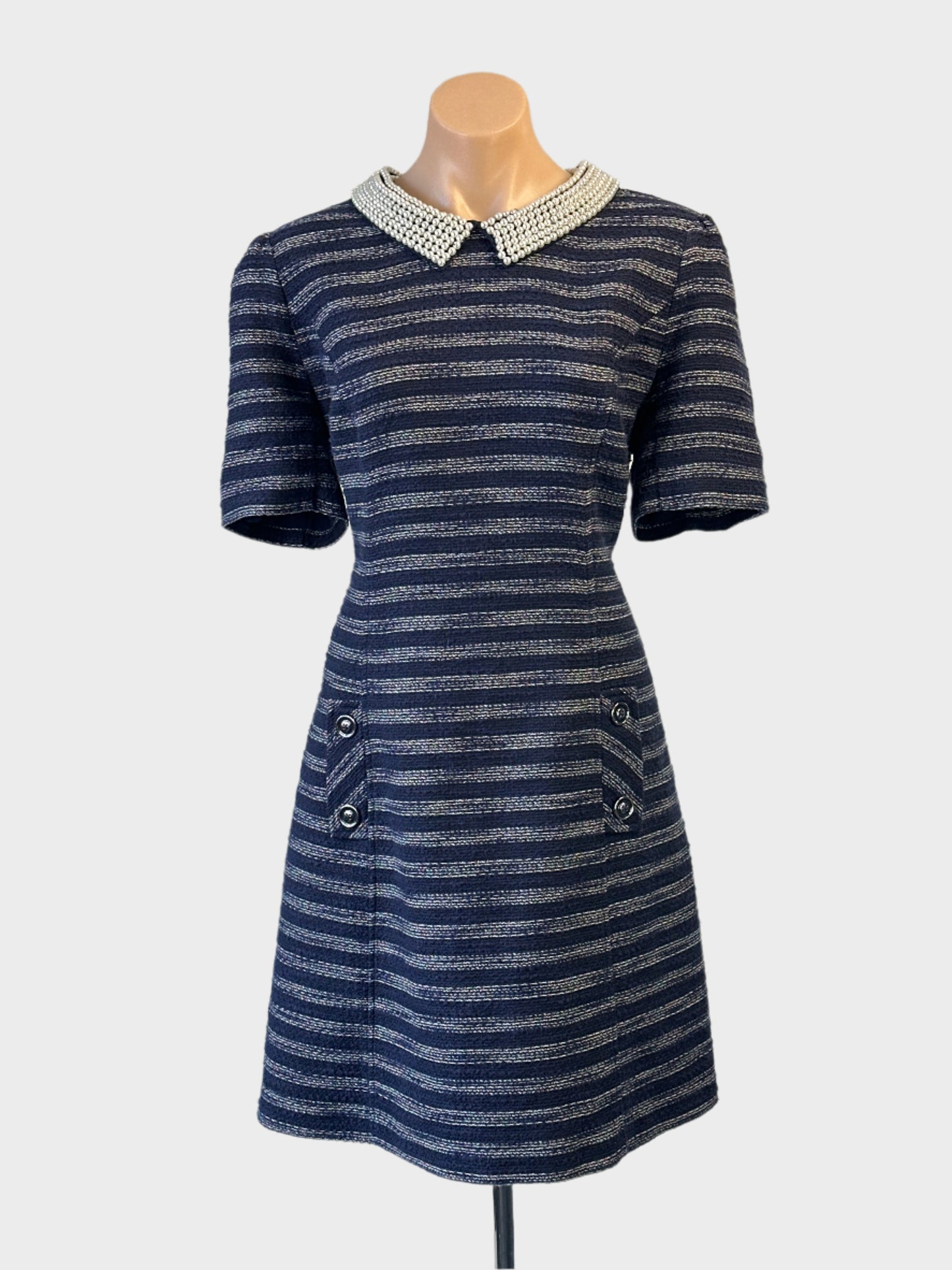 Review navy and white striped A-line dress with pearl collar and flared skirt for office or special events.