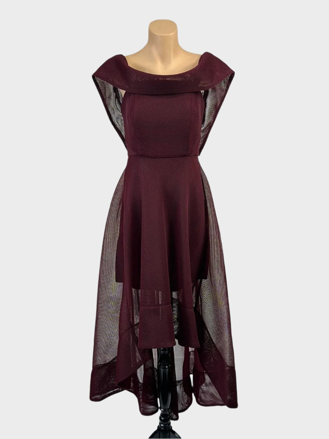 Pilgrim sleeveless A-line gown in dark plum sheer mesh with bateau neck, shawl collar, and high-low circle skirt for evening or formal wear.