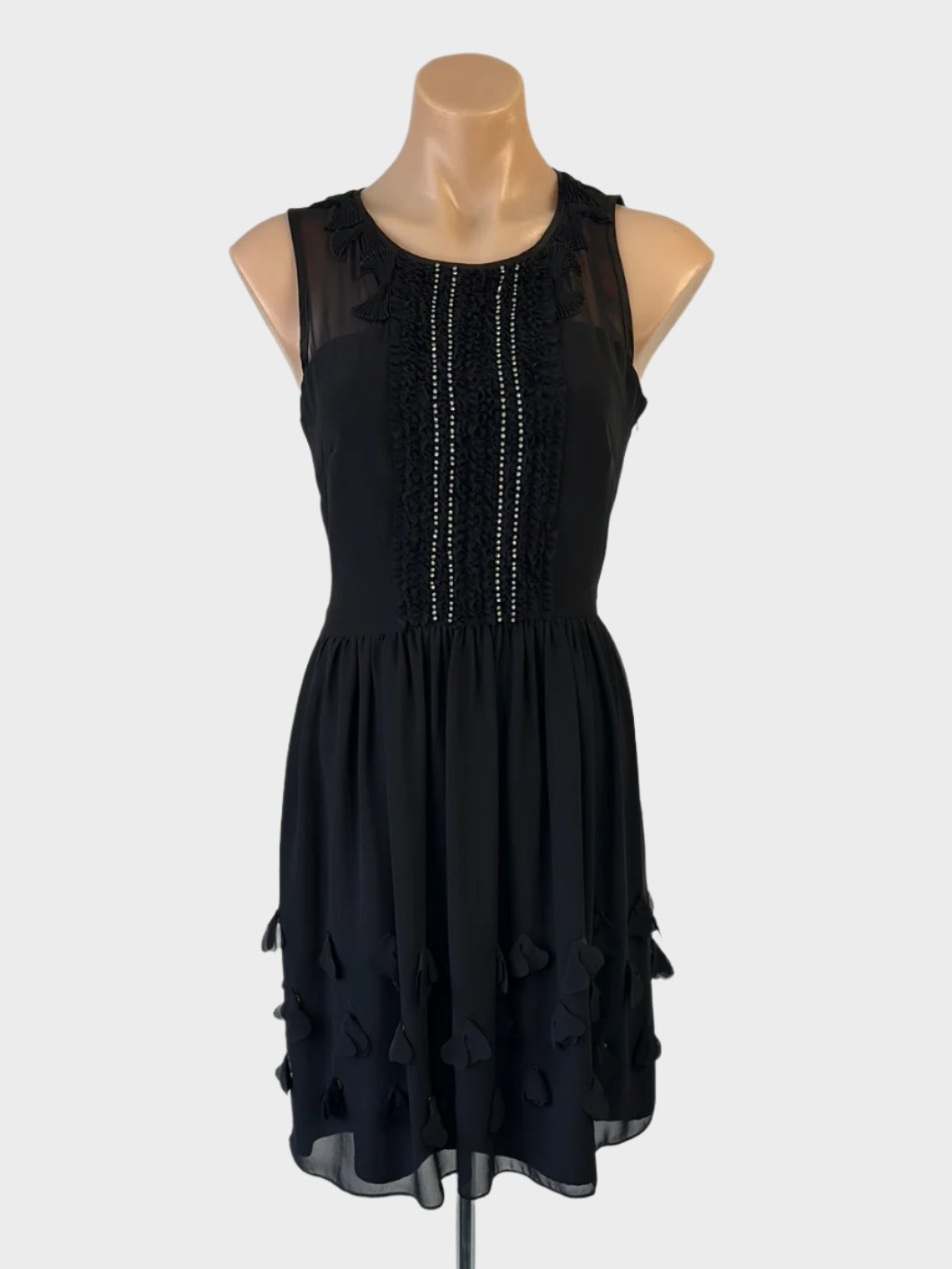 Designer Moiselle sleeveless black dress with illusion neck, pleated bows, frilled bib, keyhole back, and appliqué skirt for evening wear.