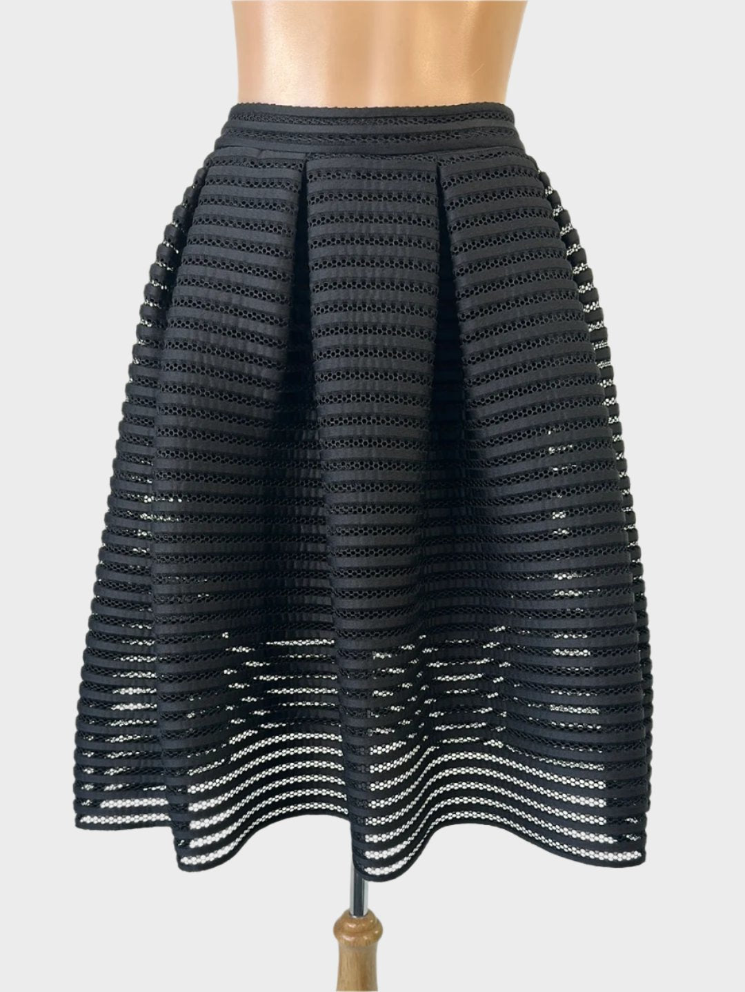 Designer Maje pleated A-line black skirt in sheer rib fabric with mini skirt underlay and narrow waistband for evening or formal wear.