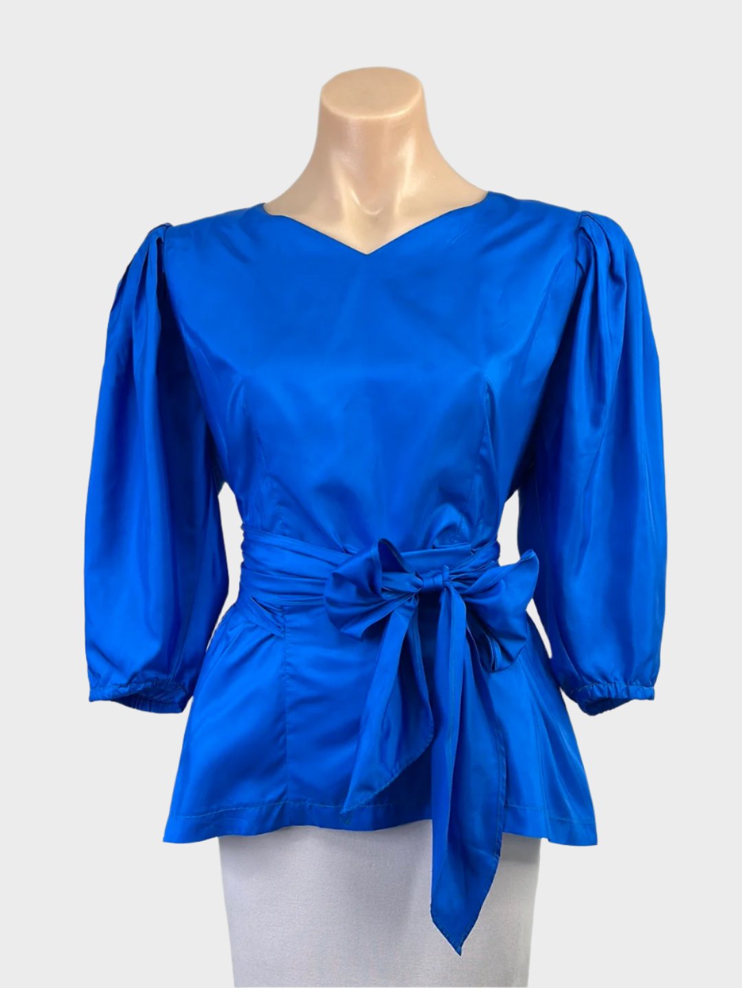 Vintage 80's peplum top in bright blue taffeta with v-neck, balloon sleeves, cummerbund waist sash, and pearl button back for evening wear.