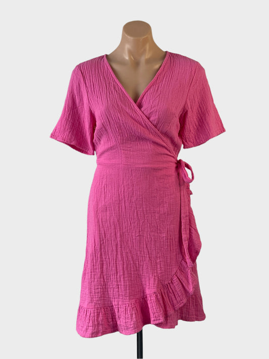 Designer ONLY wrap dress in pink organic cotton cheesecloth with short sleeves and tulip skirt for smart casual or resort wear.