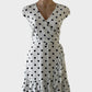 J.Crew A-line dress in white and black polka dot print, featuring cap sleeves, surplice neck, narrow waistband, and tulip skirt with ruffle trim and high-low hem for smart casual wear.