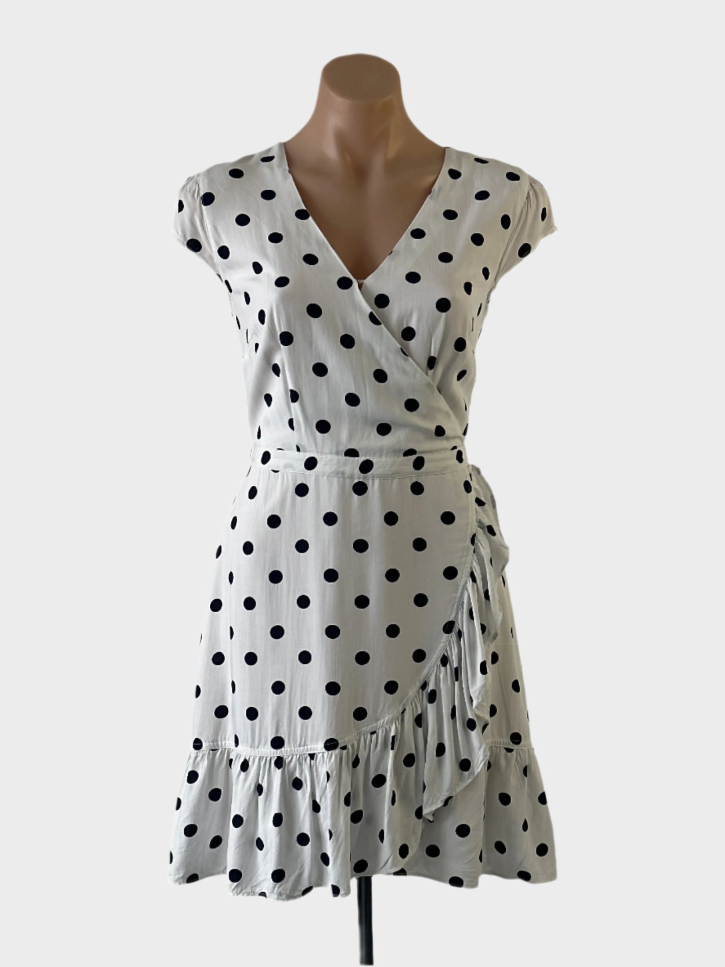 J.Crew A-line dress in white and black polka dot print, featuring cap sleeves, surplice neck, narrow waistband, and tulip skirt with ruffle trim and high-low hem for smart casual wear.