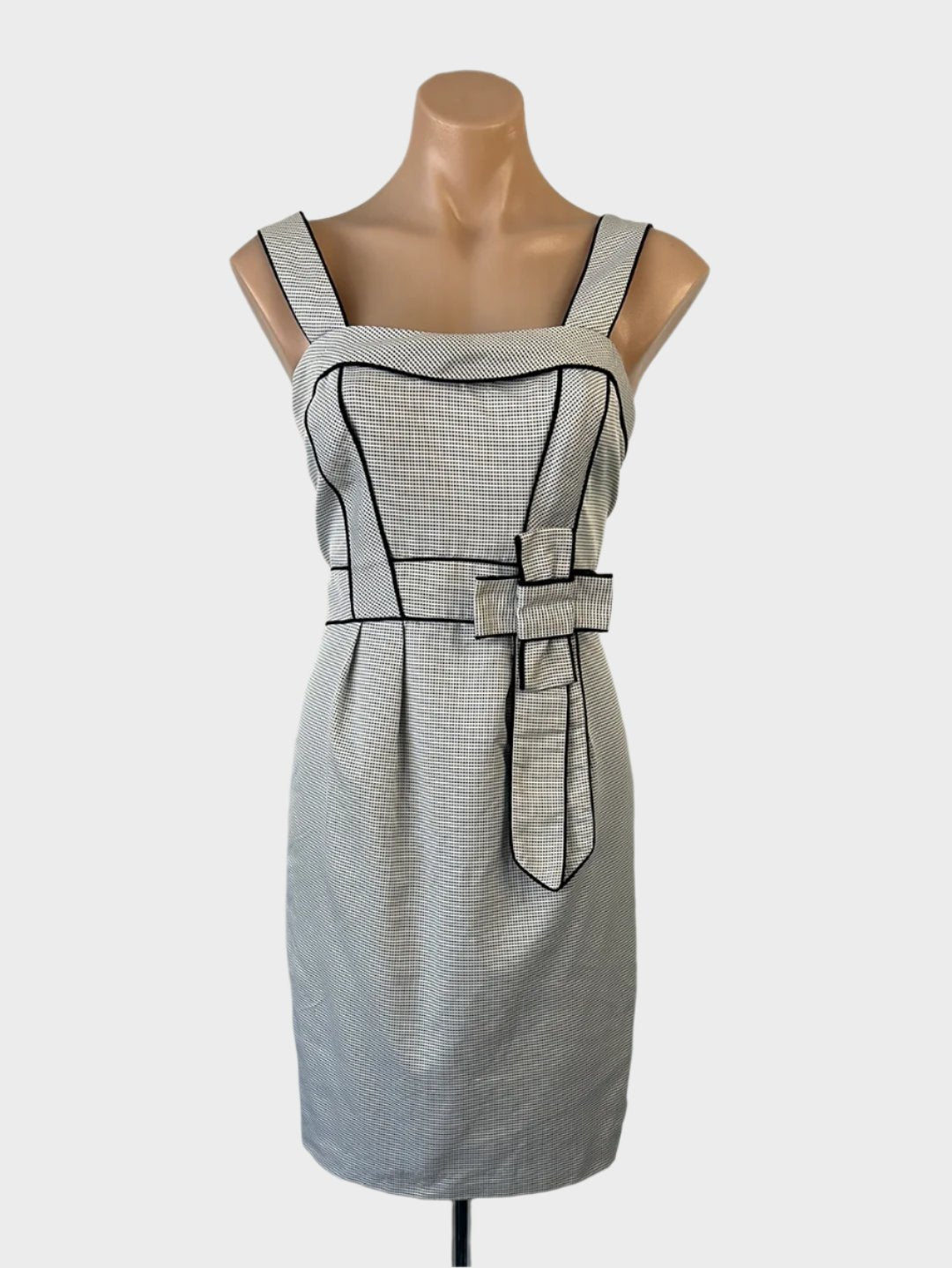 Designer Katherine sleeveless shift dress in black and white with pin dot print, rolled collar, waistband, and pleated skirt for office wear.