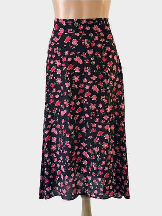 Designer PYRUS A-line skirt in black and pink floral pure silk, featuring wide waistband with tie back sash and side slit for office or smart casual occasions.