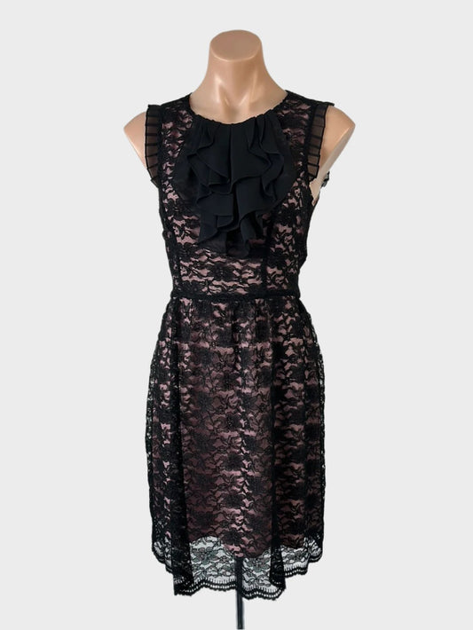 Review A-line dress in black lace with contrasting lining, featuring frilled cap sleeves, jabot collar, and pleated skirt for evening.