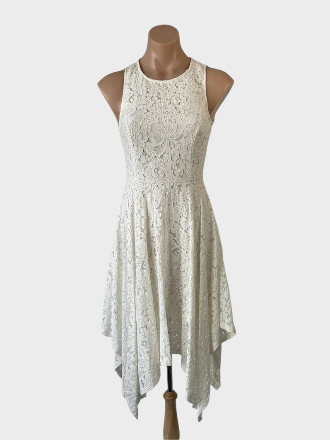 Slide Show sleeveless A-line dress in white guipure lace with round neck, keyhole back, and handkerchief hem for special events.