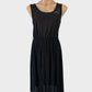 Designer St Michael vintage 80s sleeveless A-line dress in black jersey with satin finish, scoop back, and pleated skirt for evening wear.