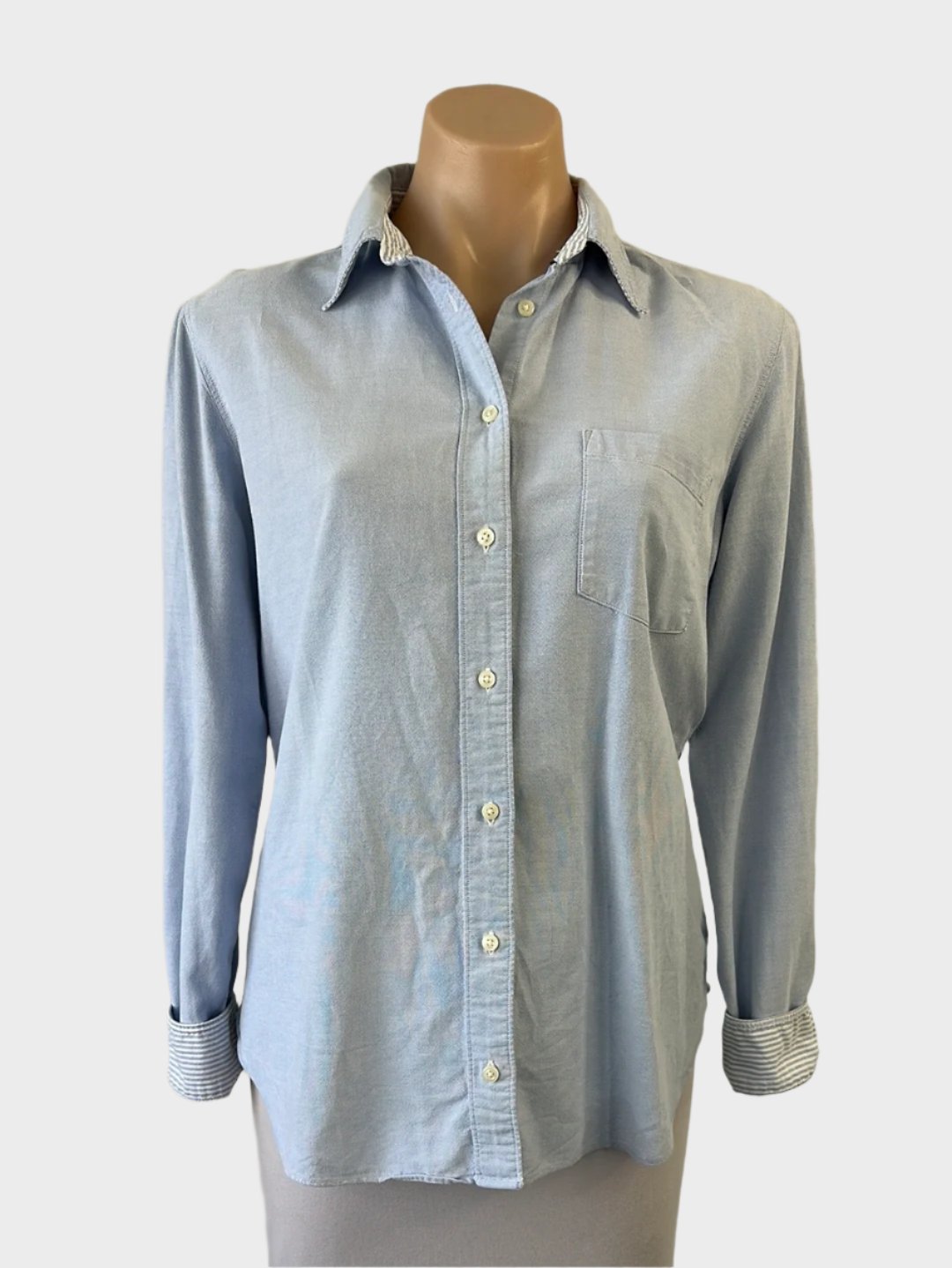 Designer Tommy Hilfiger denim shirt in light wash with striped cuffs, patch pocket, and curved hem for smart casual wear.