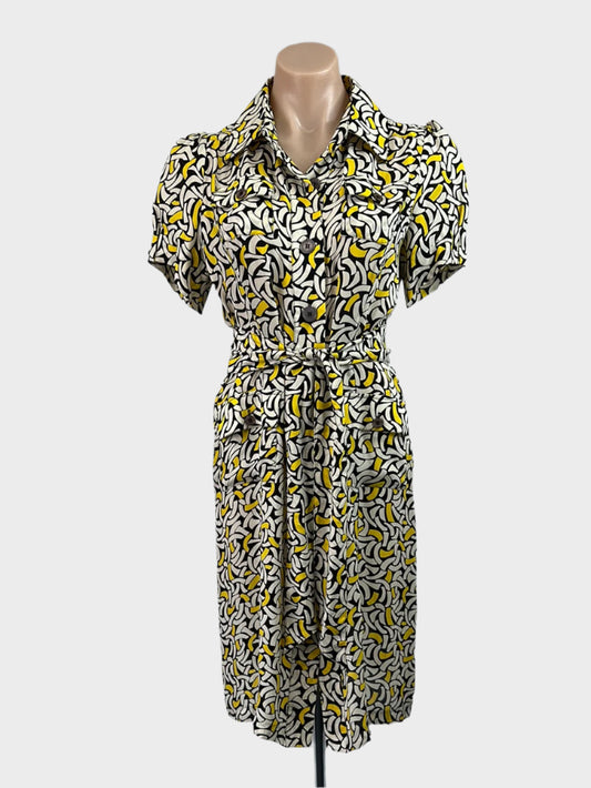 Yellow vintage 90s shirt dress in crepe with bright post-modern pattern, button-up front, short sleeves, and tie waist sash for office wear.