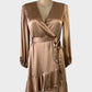 Witchery wrap dress in copper satin with surplice neck, long sleeves, waist sash, and tulip skirt with flounce hem for evening wear.