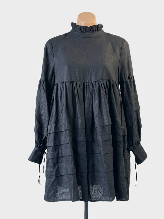 Designer Aere smock dress in black with frill collar and tiered skirt for smart casual or office wear.


