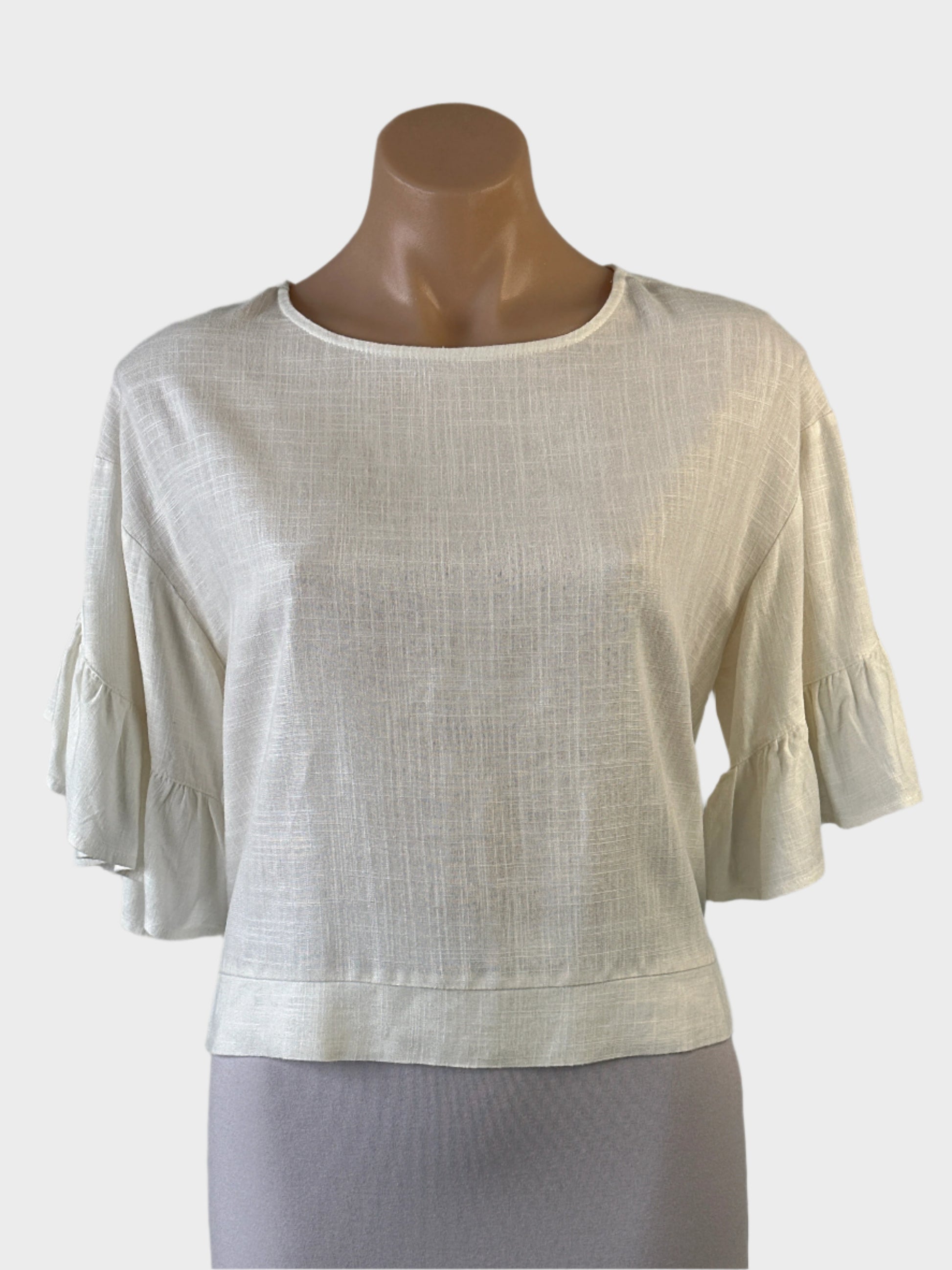 Ava top in white slub weave with round neck, ruffle cuffs and notched hip band for office or smart casual.