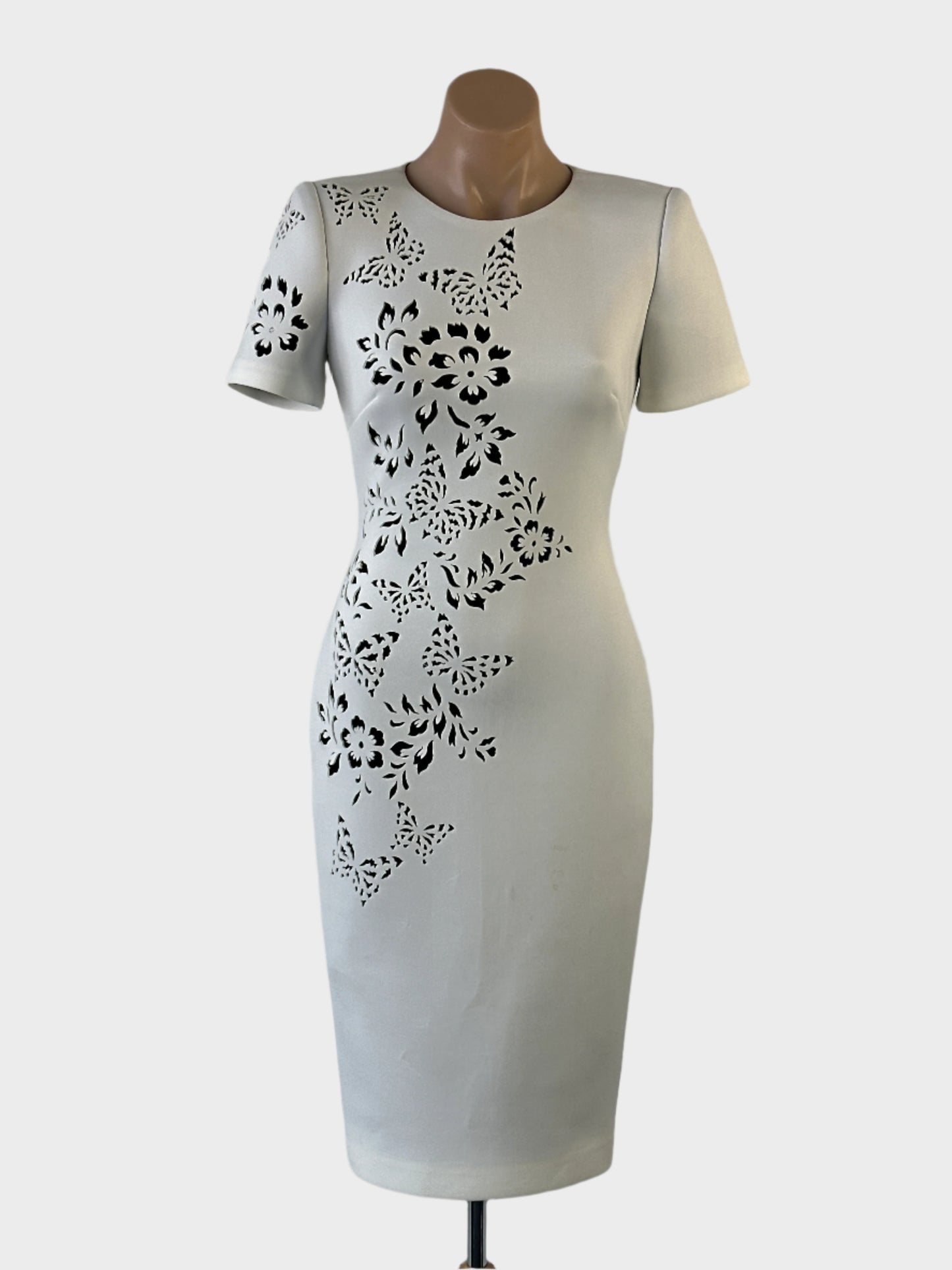 Designer Badgley Mischka sheath dress in white scuba fabric with laser cut butterfly motifs, round neck and pencil skirt for special events.