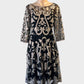 Black and beige sheer mesh A-line dress with floral appliqué, bateau neck and full skirt for evening or special events.