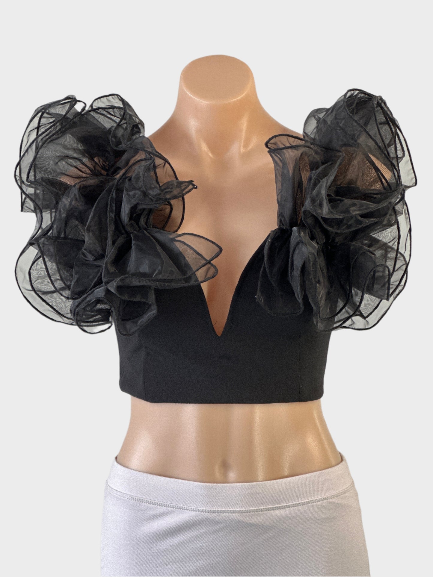 Club London crop top in black with notched neck and sheer organza ruffle for evening or formal wear.