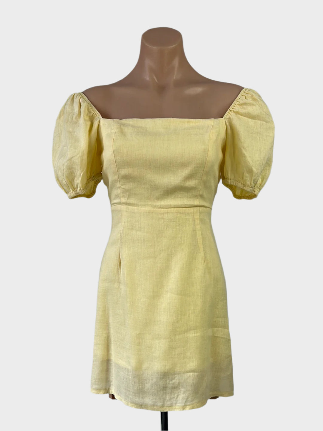 Designer DISSH yellow off the shoulder dress in pure linen with puff sleeves, shirred back, and flared skirt for smart casual or resort wear.