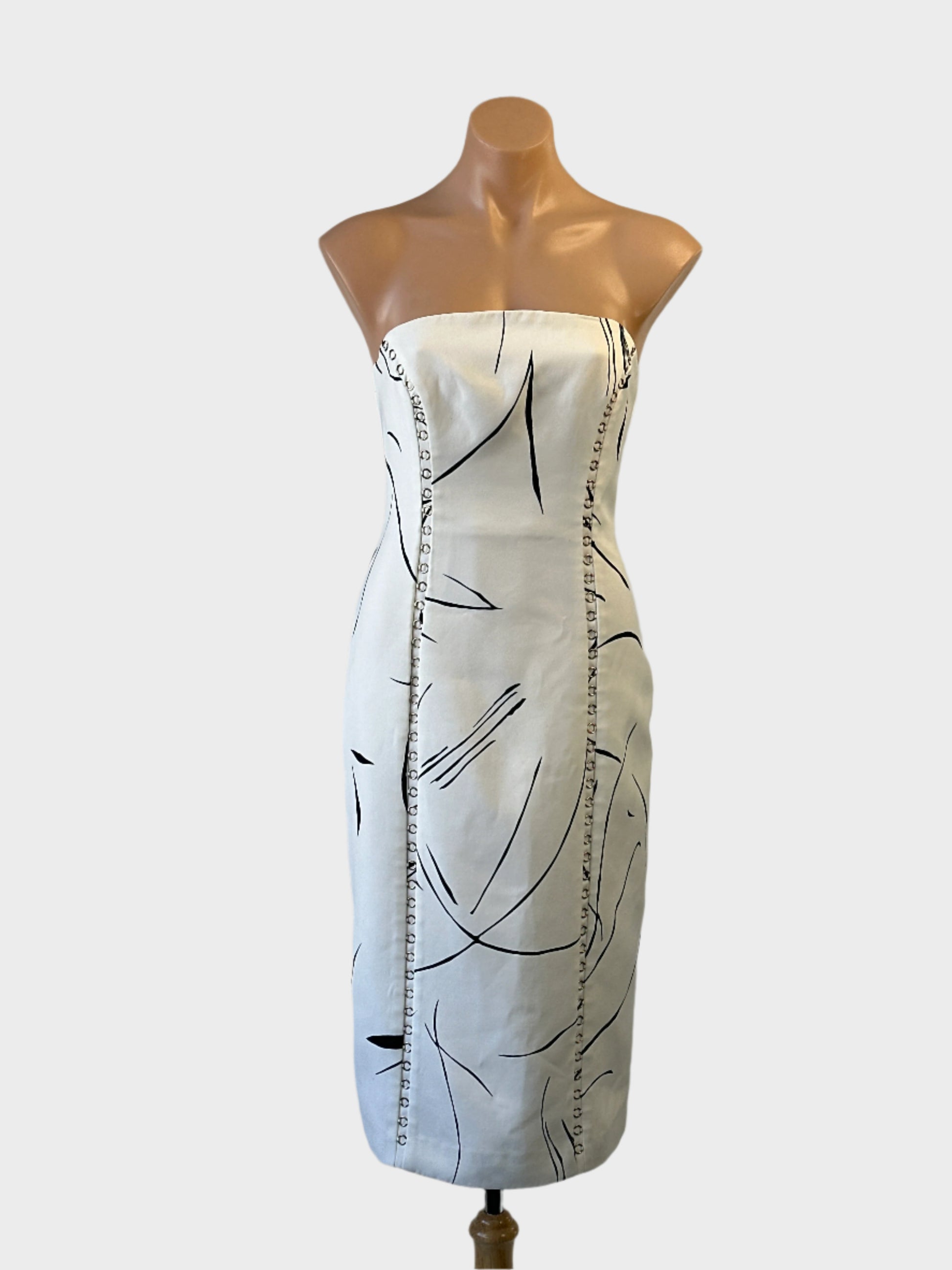 Designer Keepsake white and black line print strapless sheath dress with metal ring seams for special events or evening wear.