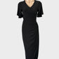 Designer Leina Broughton black wrap dress in jersey with surplice neck, flutter sleeves, and tulip skirt for office or evening wear.