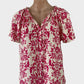 Designer VERO MODA pink and white tropical style shirt with bright botanical print, drawstring neck, and raglan sleeves for smart casual or resort wear.