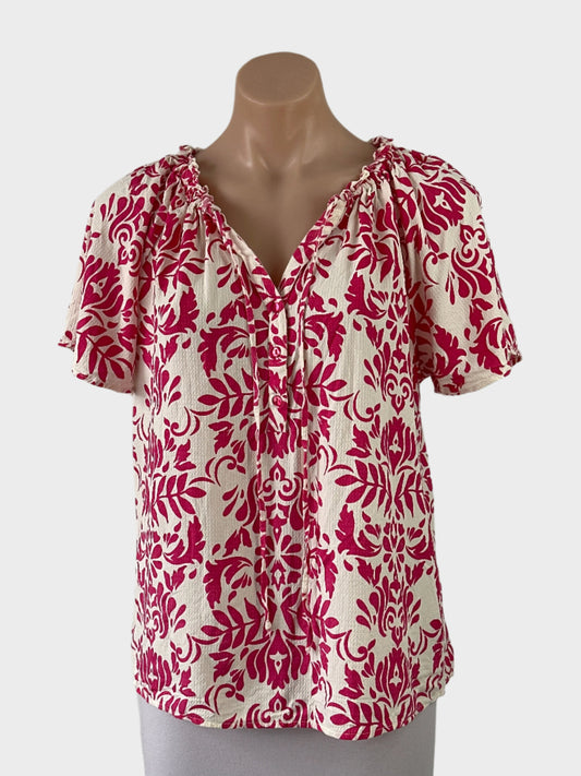 Designer VERO MODA pink and white tropical style shirt with bright botanical print, drawstring neck, and raglan sleeves for smart casual or resort wear.