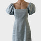 Designer DISSH off the shoulder dress in blue linen with puff sleeves, shirred back and flared skirt for smart casual wear.