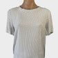 Designer Perri Cutten classic top in white crepe with black dot print, featuring a bateau neck, short sleeves, and notched hem for office wear.