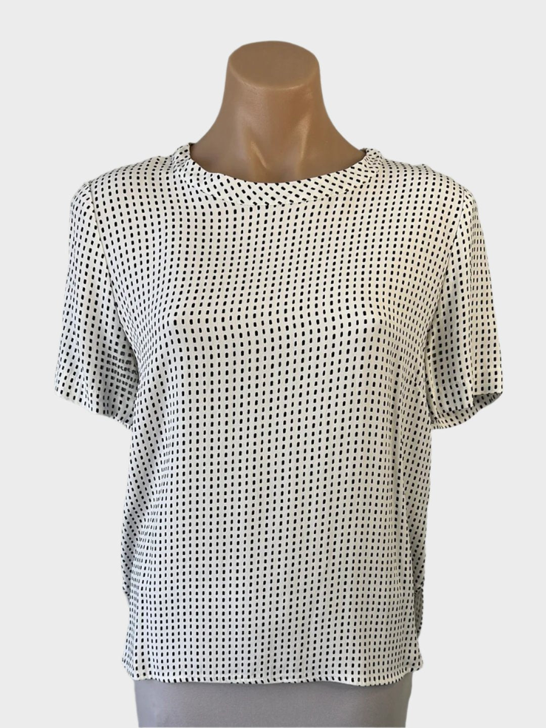 Designer Perri Cutten classic top in white crepe with black dot print, featuring a bateau neck, short sleeves, and notched hem for office wear.