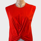 Designer Husk sleeveless top in orange jersey with draped front panel for resort or smart casual wear.