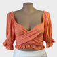 Jaase crop top in pink and orange paisley print with wrap front and puff sleeves for resort or smart casual wear.