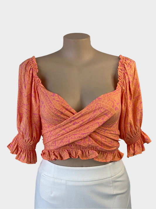 Jaase crop top in pink and orange paisley print with wrap front and puff sleeves for resort or smart casual wear.