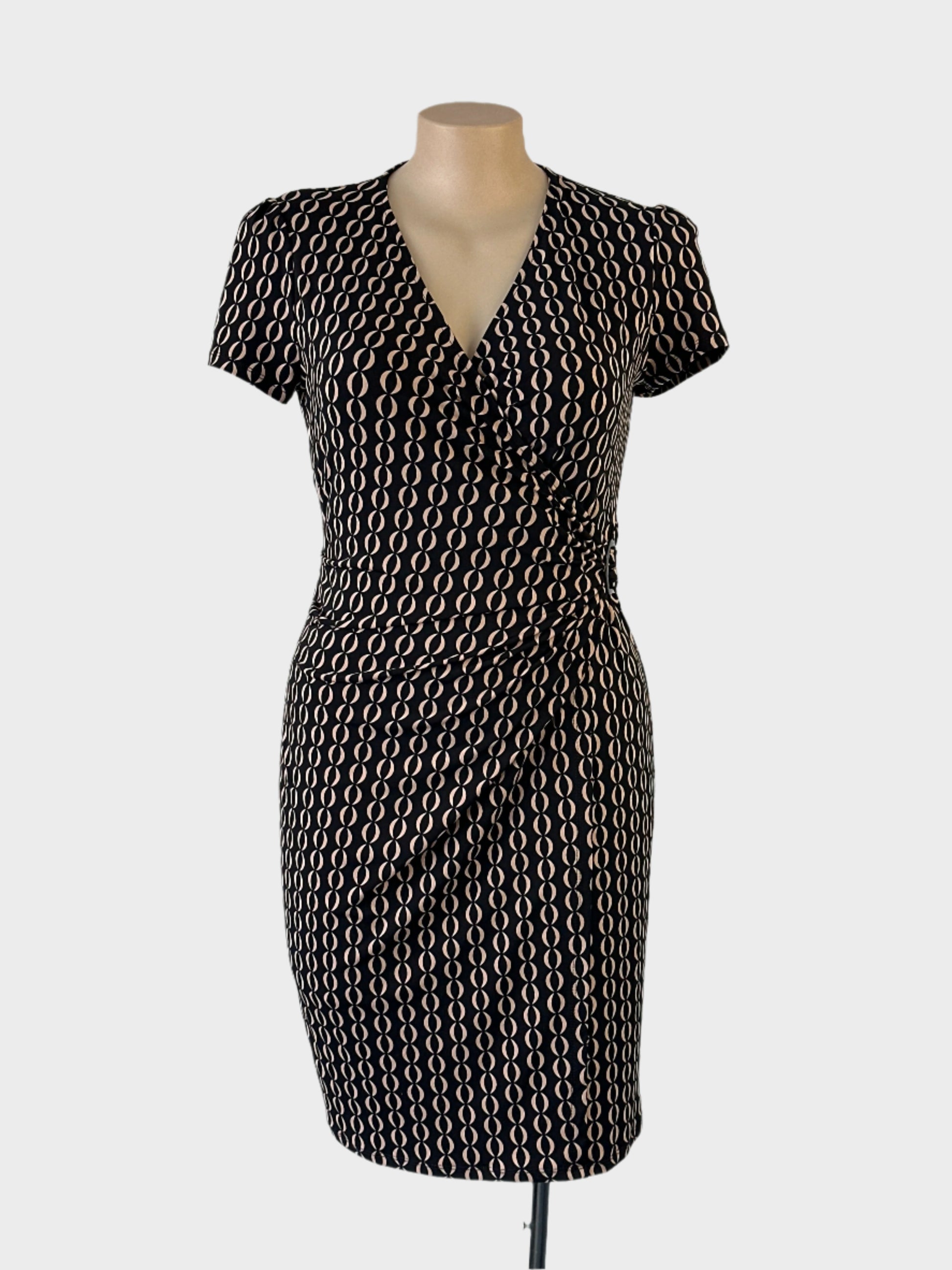 Jacqui E sheath dress in black & beige jersey with chain style print, surplice neck and draped skirt for office wear.