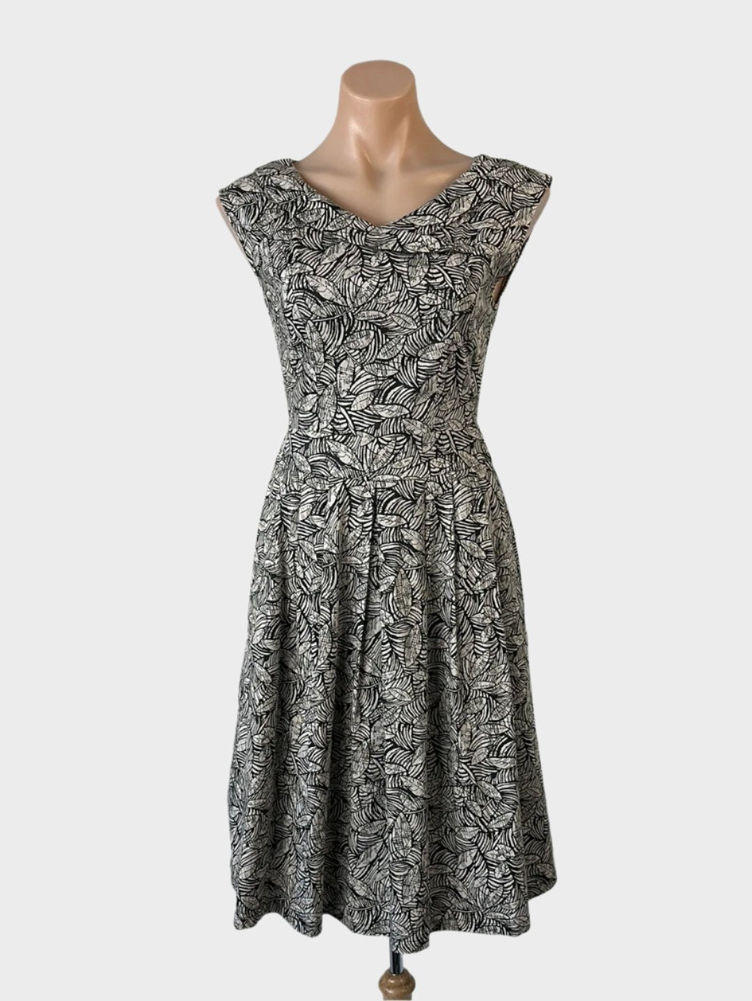 Love is Found retro 50's sleeveless A-line dress in beige botanical print with bateau neck, wide waistband, and pleated skirt for smart casual wear.