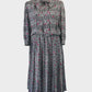 Vintage 80’s Noel Wells blouson dress in houndstooth check with contrasting flecks, band collar with pussy bow tie, and pleated skirt for office or special events.