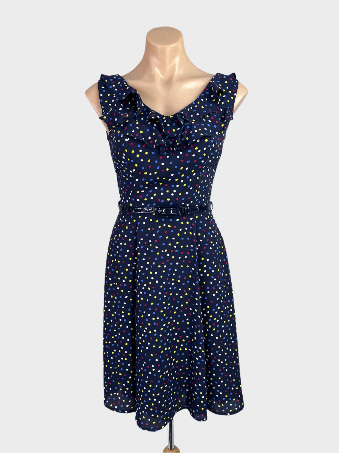 Review blue sleeveless A-line dress with dot print, v-neck with ruffle trim, skinny belt and full panel skirt for office wear.