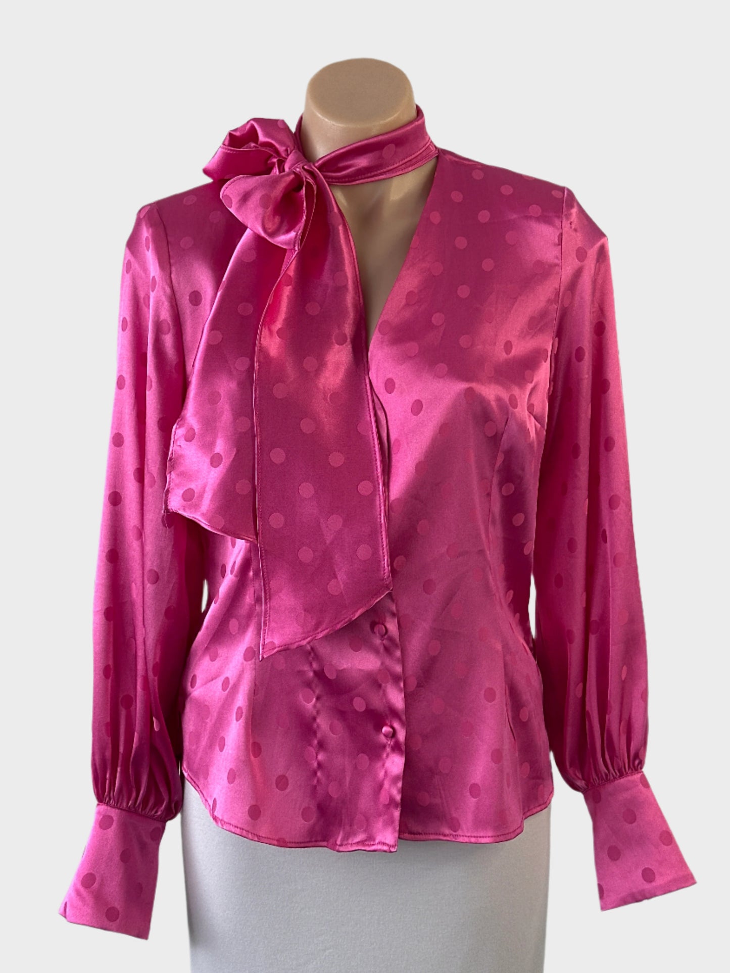 River Island shirt in pink polka dot jacquard with satin finish, pussy bow, long sleeves and back yoke for office or smart casual wear.