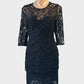Seed lace sheath dress in black with illusion neck and peplum waist for evening wear.