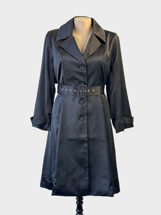 Taking Shape trench coat in black satin finish with matching belt and storm flap for evening wear.