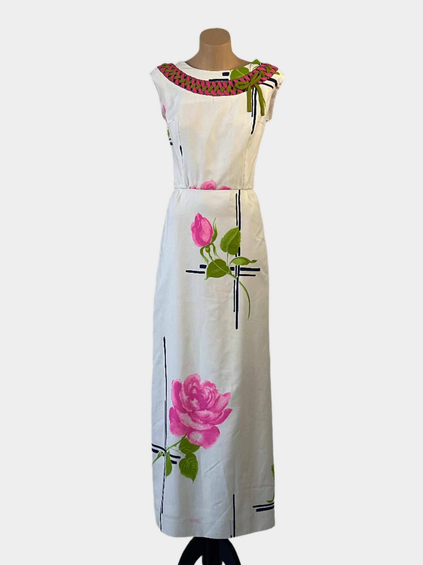 White sheath dress with floral print, contrasting yoke with braiding and bow, and straight skirt for special events or evening wear.