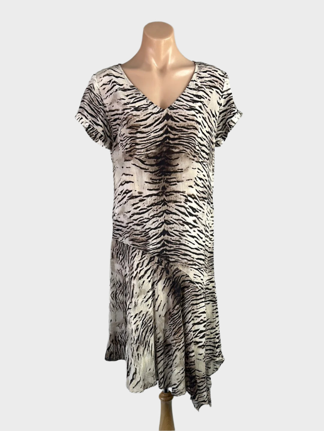 Zebra print drop waist dress in silk crepe with v-neck, cap sleeves, and high-low flounce skirt for smart casual or special events wear.